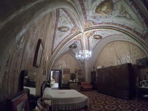 a room with a bed and a ceiling with a chandelier at PENSIONE ITALIA in Bolsena