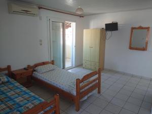 a bedroom with two beds and a cabinet and a window at House Papus in Sarti