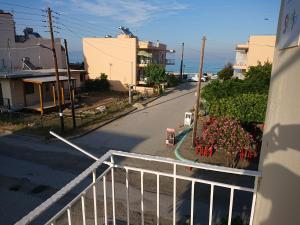 an empty street with a white fence and flowers at House Papus in Sarti