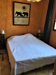 1 dormitorio con 1 cama con una foto de caballos en la pared en Rez-de Villa Piscine, en Cavalaire-sur-Mer