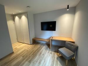 una stanza con una scrivania e una TV a parete di Ver'Olive a Francorchamps