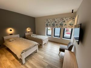 una camera da letto con un letto, una sedia e due finestre di Ver'Olive a Francorchamps