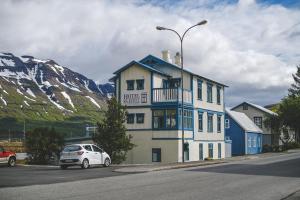 a white car parked in front of a building at Hotel Aldan - The Post Office in Seyðisfjörður