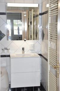 een badkamer met een witte wastafel en een spiegel bij Anna 1 in Grächen