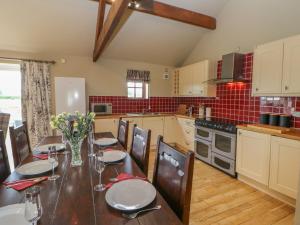 a kitchen with a wooden table with chairs and a dining room at Ellaberry in Darlington