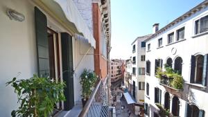 Blick auf eine Gasse vom Balkon eines Gebäudes in der Unterkunft Ai Bareteri Luxury Canal View in Venedig