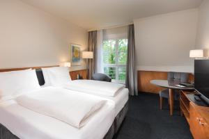 Seminaris Hotel Leipzig في لايبزيغ: غرفه فندقيه سريرين وتلفزيون