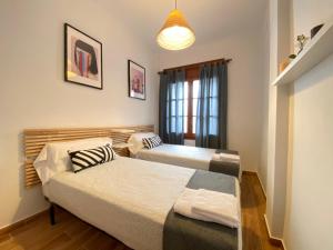 a room with two beds and a window at Apartments Sant Lluis CENTER, 2 min walk from the sea in Lloret de Mar