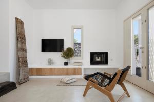 a living room with a chair and a tv at Casa Luz in Pyrgos