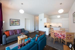 ein Wohnzimmer mit einem blauen Sofa und einem Tisch in der Unterkunft Centralhof A 22 in Davos