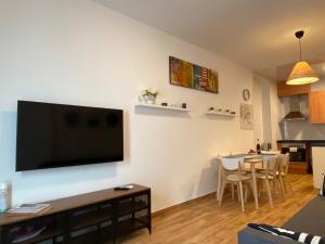 sala de estar con TV de pantalla plana en la pared en Apartments Sant Lluis CENTER, 2 min walk from the sea en Lloret de Mar