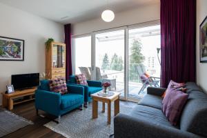 a living room with two blue couches and a television at Centralhof A 22 in Davos