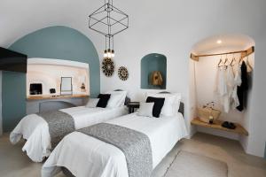two beds in a room with white and blue at Casa Luz in Pyrgos