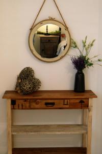 un espejo en una pared sobre una mesa de madera en Aegean Blue Houses en Mandrakia