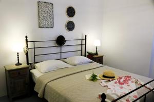 a bedroom with a bed with a hat on it at Aegean Blue Houses in Mandrakia