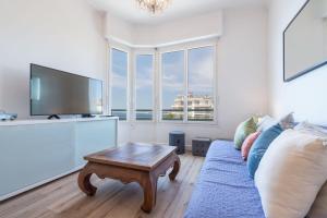 uma sala de estar com um sofá e uma mesa de centro em Sea View - Promenade des Anglais 1 Bdr em Nice