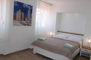 una camera con un letto e una foto appesa al muro di Jeta Studio & Rooms a Zara (Zadar)