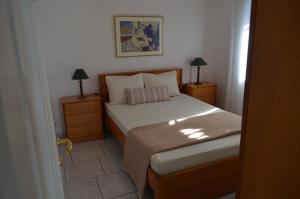 a small bedroom with a bed and two night stands at Blue Maison in Paralia Katerinis