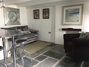 a living room with a couch and a table at The Padstow Cottage (Coswarth House) in Padstow