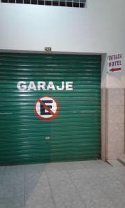 a green garage door with a no parking sign on it at Hotel Boston in Guayaquil