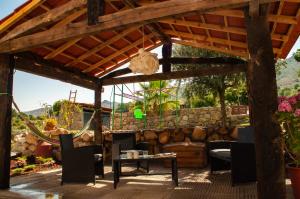 eine hölzerne Pergola mit einem Tisch und Stühlen auf einer Terrasse in der Unterkunft Quintinha Viçosa in Aldeia Viçosa