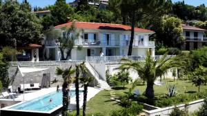 a view of a house with a swimming pool and palm trees at Portorož Apartments in Portorož