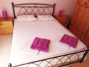クリオピギにあるEmerald Apartment with Sea Viewのベッド1台(紫色のタオル2枚付)