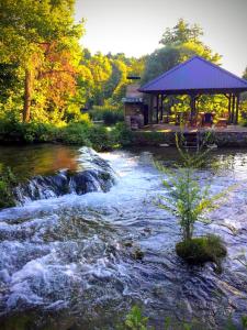a river with a gazebo in the middle of a river with at Apartman San Slunj Rastoke in Slunj