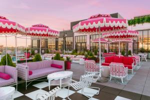 une terrasse avec des meubles et des parasols roses et blancs dans l'établissement Graduate Nashville, à Nashville