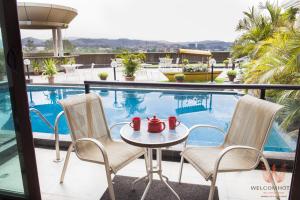 eine Terrasse mit einem Tisch und Stühlen neben einem Pool in der Unterkunft Welcomhotel by ITC Hotels, Bella Vista, Panchkula - Chandigarh in Chandīgarh