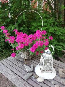 a table with a basket of flowers and a lantern at Countryside house Villa Pauliina -lomatalo in Jämijärvi