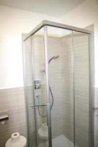 a glass shower with a toilet in a bathroom at Pension Ridnauntal in Racines