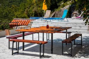 a wooden table and benches with a table and chairs at Villas Adriatic Horizonte in Budva