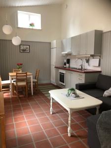 ein Wohnzimmer mit einem Sofa und einem Tisch sowie eine Küche in der Unterkunft Gårdshuset in Söderköping