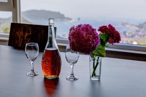 three wine glasses and a vase with flowers on a table at Villas Adriatic Horizonte in Budva +118 photos