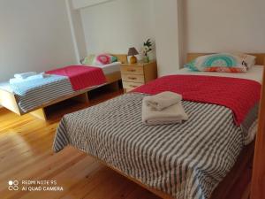 zwei Einzelbetten in einem Zimmer mit Holzboden in der Unterkunft Casa da Neta in Açor