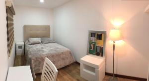 a small bedroom with a bed and a lamp at H CASE in San Juan Cosalá