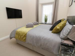 a bedroom with a bed with a television on the wall at Nappers Cottage in Hayle