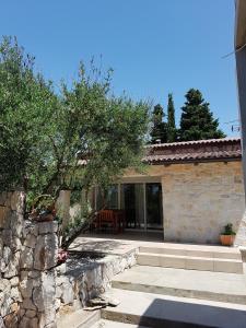 a house with a stone wall and a patio at APARTMANI MOROVI DVORI in Drage