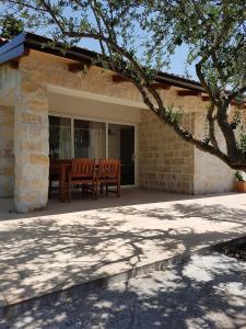 a patio of a house with a table and chairs at APARTMANI MOROVI DVORI in Drage