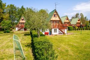 ein Blockhaus mit einem Zaun davor in der Unterkunft The Rainbow - Domki Letniskowe in Dźwirzyno