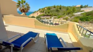 Un balcón con sillas azules y vistas al océano. en Centeanes Beach apartment, en Carvoeiro