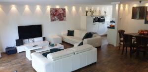 a living room with a white couch and a table at Lake House 74, luxury accommodation ir Sauna in Warmond