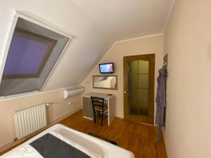 a room with a bed and a desk and a window at Vila Eszter in Sovata