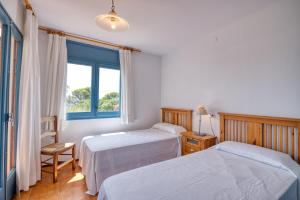 1 Schlafzimmer mit 2 Betten und einem Fenster in der Unterkunft Second line in Calella with seaviews in Calella de Palafrugell