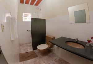 uma casa de banho com um lavatório, um WC e um espelho. em Pousada Aconchego Da Serra em Serra do Cipó