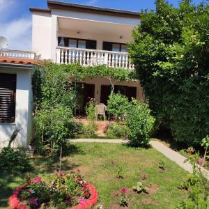 a house with a garden in front of it at Apartments Tessa 77 in Medulin