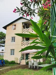 a building with tables and chairs in front of it at Ureki House in Ureki