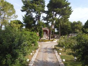 Villa Grazia في Latiano: ممر يؤدي إلى منزل به أشجار