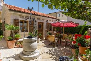 eine Terrasse mit einem Brunnen, einem Tisch und einem Sonnenschirm in der Unterkunft Guesthouse Casa Nova in Poreč